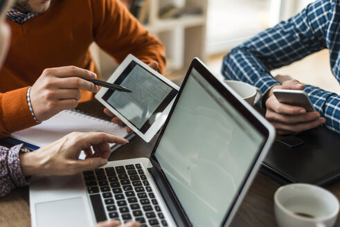 Kollegen am Schreibtisch mit Blick auf eine digitale Tafel, die verschiedene Formen zeigt - UUF006383