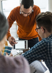 Kollegen im Büro schauen auf eine digitale Tafel, die verschiedene Formen zeigt - UUF006394