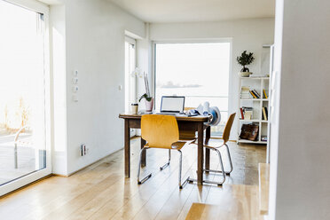 Laptop on wooden desk in an apartment - UUF006414