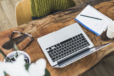 Laptop, notepad and glasses on wooden desk - UUF006416