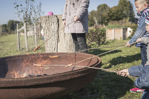 Deutschland, Brandenburg, Kinder braten Würstchen am Feuer - ASCF000500