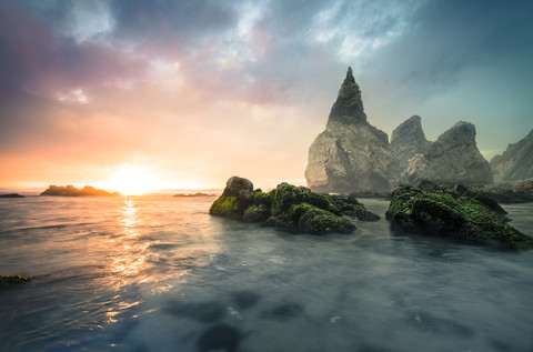 Portugal, Praia Ursa, Steinformationen am Strand in der Morgensonne, lizenzfreies Stockfoto