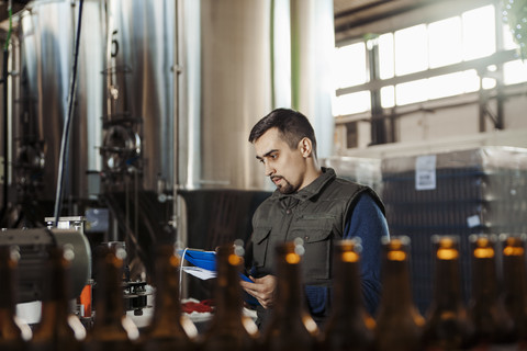 Junger Mann arbeitet in einer Handwerksbrauerei, lizenzfreies Stockfoto