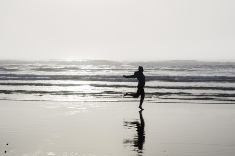 USA, Washington State, woman jumping on Long Beach stock photo