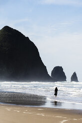 USA, Oregon, Cannon Beach, Haystack Rock, woman on the beach - NGF000264