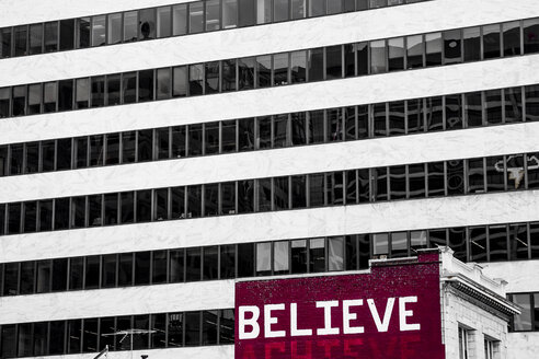 USA, San Francisco, 'Believe' painted on an old residential house in front of a high-rise building - NGF000271