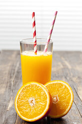 Sliced orange and glass of orange juice on wood - CSF027027