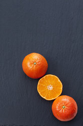 Ganze und in Scheiben geschnittene Mandarinen auf Schiefer - CSF027061