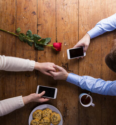 Young couple holding hands and their smartphones - HAPF000173