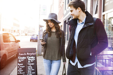 Germany, Berlin, young couple walking along sidewalk - GCF000134