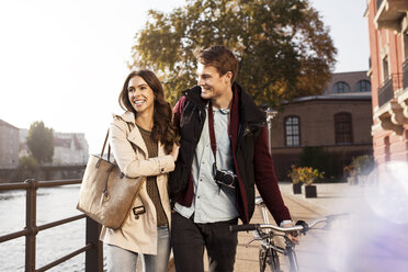 Germany, Berlin, happy young couple walking along River Spree - GCF000155