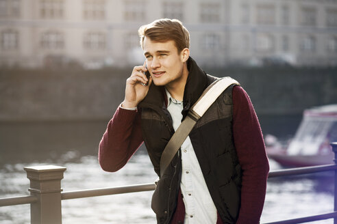 Deutschland, Berlin, junger Mann am Telefon an der Spree - GCF000161