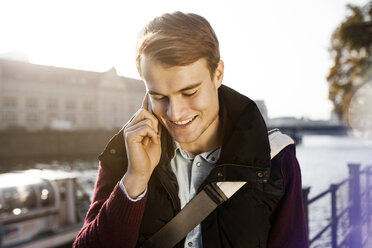 Germany, Berlin, young man on the phone at River Spree - GCF000162