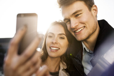 Lächelndes junges Paar macht ein Selfie im Freien - GCF000171