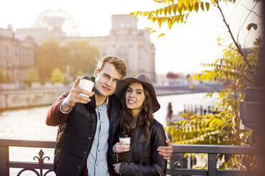 Germany, Berlin, young couple at River Spree with coffee to go - GCF000173