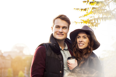 Lächelndes junges Paar mit Kaffee zum Mitnehmen, lizenzfreies Stockfoto