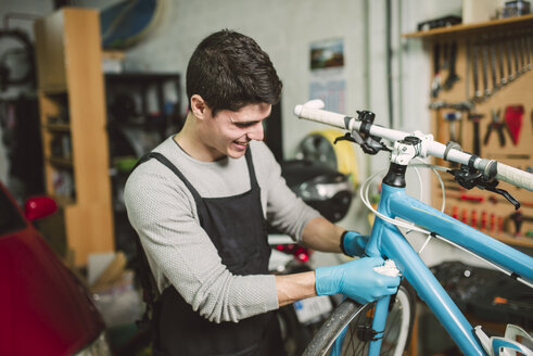 Mechaniker repariert ein Fahrrad in seiner Werkstatt - RAEF000824