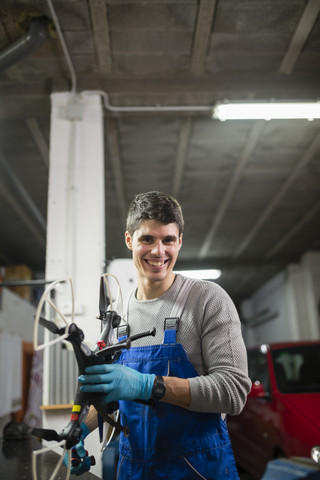 Porträt eines Mechanikers in seiner Werkstatt bei der Reparatur einer Drohne, lizenzfreies Stockfoto