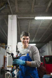 Porträt eines Mechanikers in seiner Werkstatt bei der Reparatur einer Drohne - RAEF000831