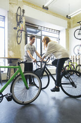Kunde testet Rennrad in einem Geschäft für maßgeschneiderte Fahrräder - JUBF000099