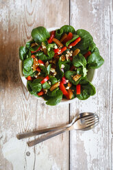 Schüssel mit gemischtem Salat, Gabel und Löffel auf Holz - EVGF002790