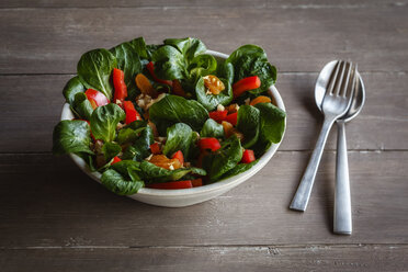 Schüssel mit gemischtem Salat, Gabel und Löffel auf Holz - EVGF002793