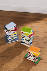 Three stacks of books on wooden floor - WDF003513