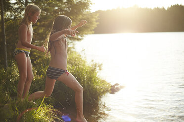 Schweden, zwei Mädchen springen in den See - TSFF000012