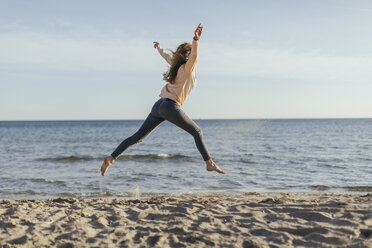 Spain, Lleida, woman jumping on the beach - JPF000110