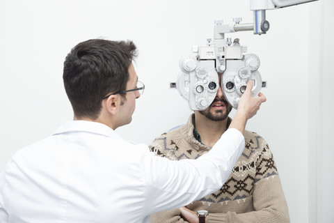 Optometrist examining eyesight of a man stock photo