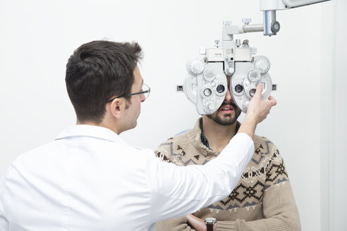 Optometrist untersucht die Sehkraft eines Mannes - ERLF000123