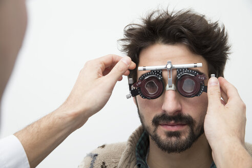 Mann beim Optiker, der einen Sehtest macht - ERLF000125