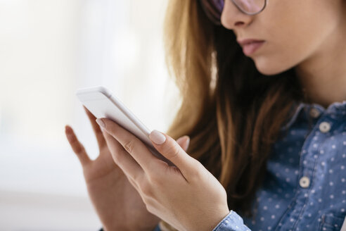 Hands of young woman using smartphone - AKNF000042