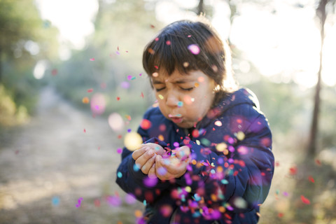 Little boy blowing confetti into the air stock photo