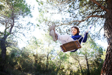 Spanien, Siurana, kleiner Junge hat Spaß auf einer Schaukel im Wald - VABF000134