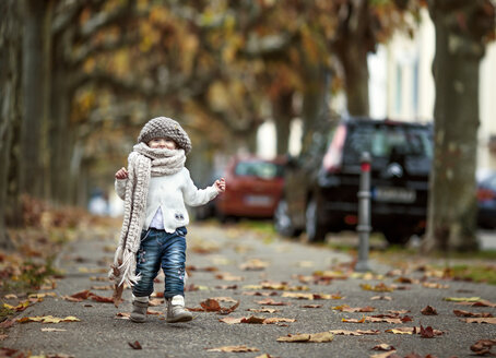 Porträt eines glücklichen kleinen Mädchens mit großem Schal und Wollmütze im Herbst - NIF000073