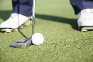 Nahaufnahme eines Golfspielers, der bereit ist, einen Golfball auf dem Grün eines Golfplatzes abzuschlagen - ABZF000187