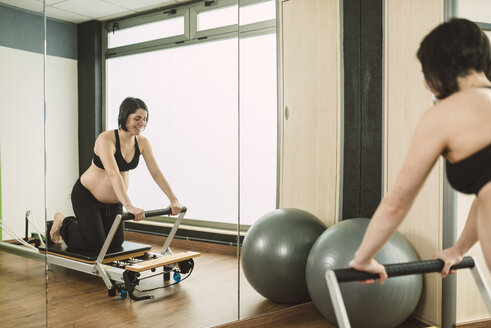 Schwangere Frau bei Pilates-Übungen in einem Fitnessstudio - RAEF000851