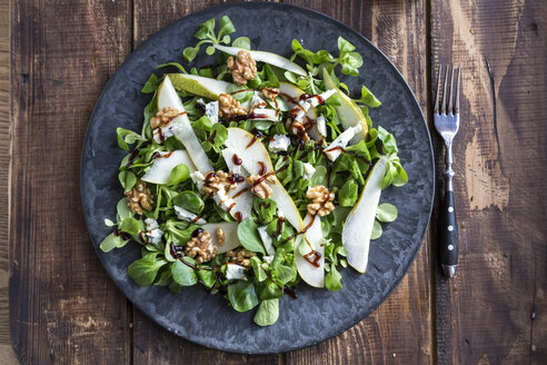 Feldsalat mit Birne, Gorgonzola und Walnuss auf Teller, Gabel - SARF002533