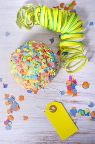 Bismarck-Doughnut mit Zuckerkonfetti, Luftschlange und gelbem Anhänger, lizenzfreies Stockfoto