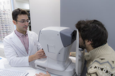 Optometrist untersucht die Sehkraft eines Mannes - ERLF000126