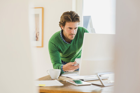 Young man working at home office stock photo