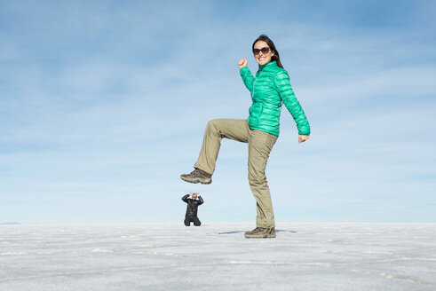 Bolivien, Salar de Uyuni, Frau tritt kleinen Mann, optische Täuschung - GEMF000711