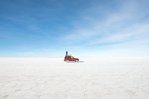 Bolivien, Atacama, Altiplano, Salar de Uyuni, Mann steht auf einem 4x4 Auto - GEMF000714