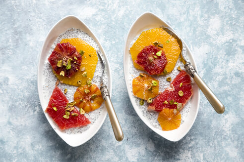 Chia Pudding und Orangenscheiben Blutorange und Grapefruit, Schalen auf Holz - SARF002539