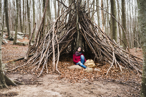 Spanien, Barcelona, Santa Fe del Montseny, Frau sitzt in einer Hütte und ruht sich aus, lizenzfreies Stockfoto