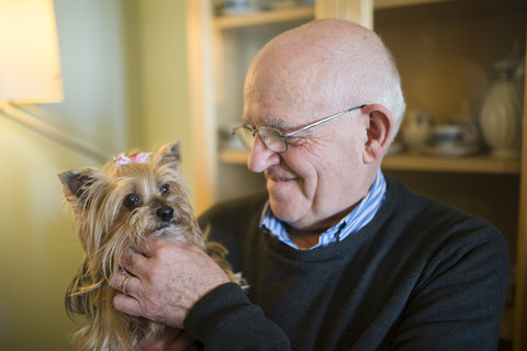 Älterer Mann mit seinem Yorkshire-Terrier zu Hause, lizenzfreies Stockfoto