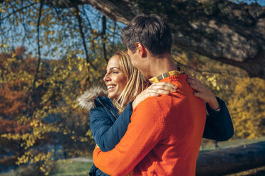 Happy couple embracing in autumn forest - CHAF001569