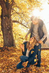 Glückliches Paar hat Spaß im Herbst in einem Wald - CHAF001590