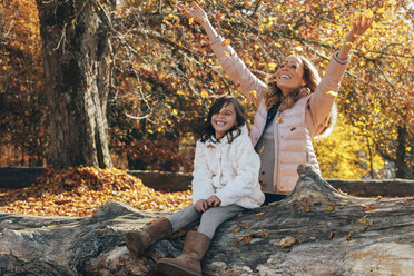 Mother and her little daughter having fun in the autumnal forest - CHAF001640